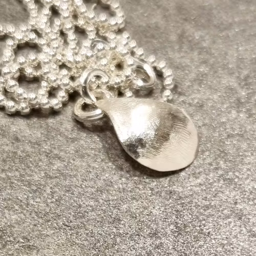 Silverhalsband med handsmidd stiliserad blåmussla med pärla
