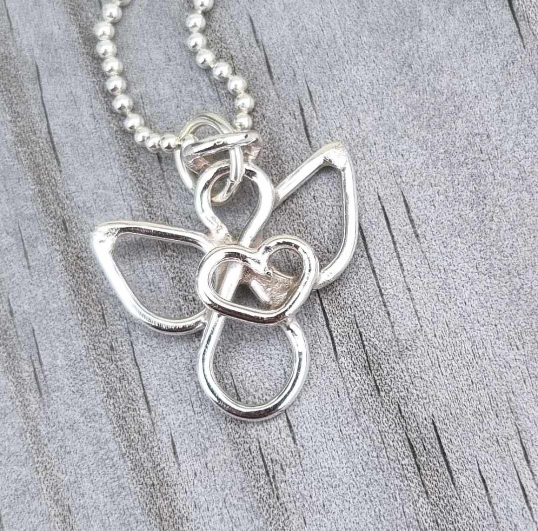 Small handmade silver angel with an eternity sign as a body