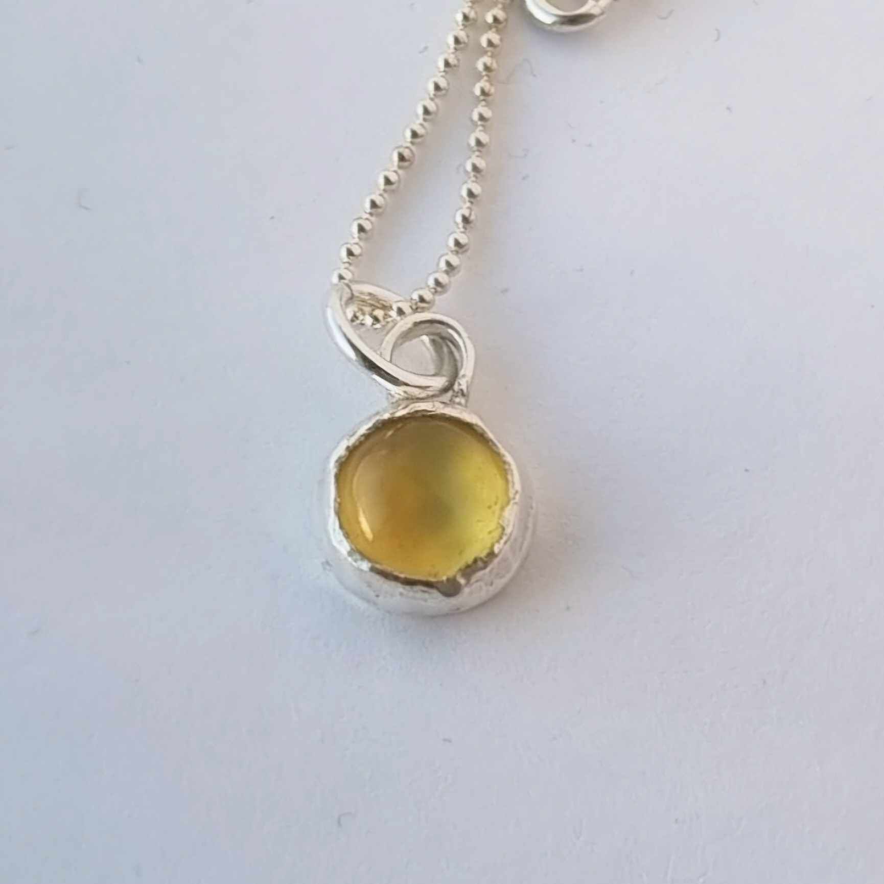 Silverhalsband med infattad gul sten, cabochon