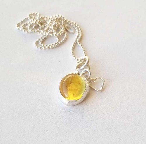 Yellow glass cabochon set in sterling silver with a tiny heart necklace