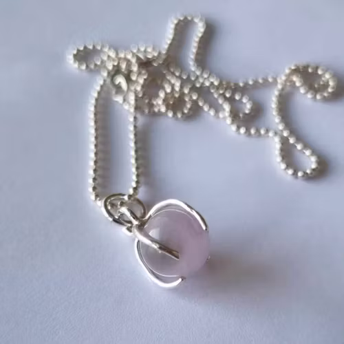 Ett fint halsband med en ljus lila/rosa sten, rund, infattad i äkta silver