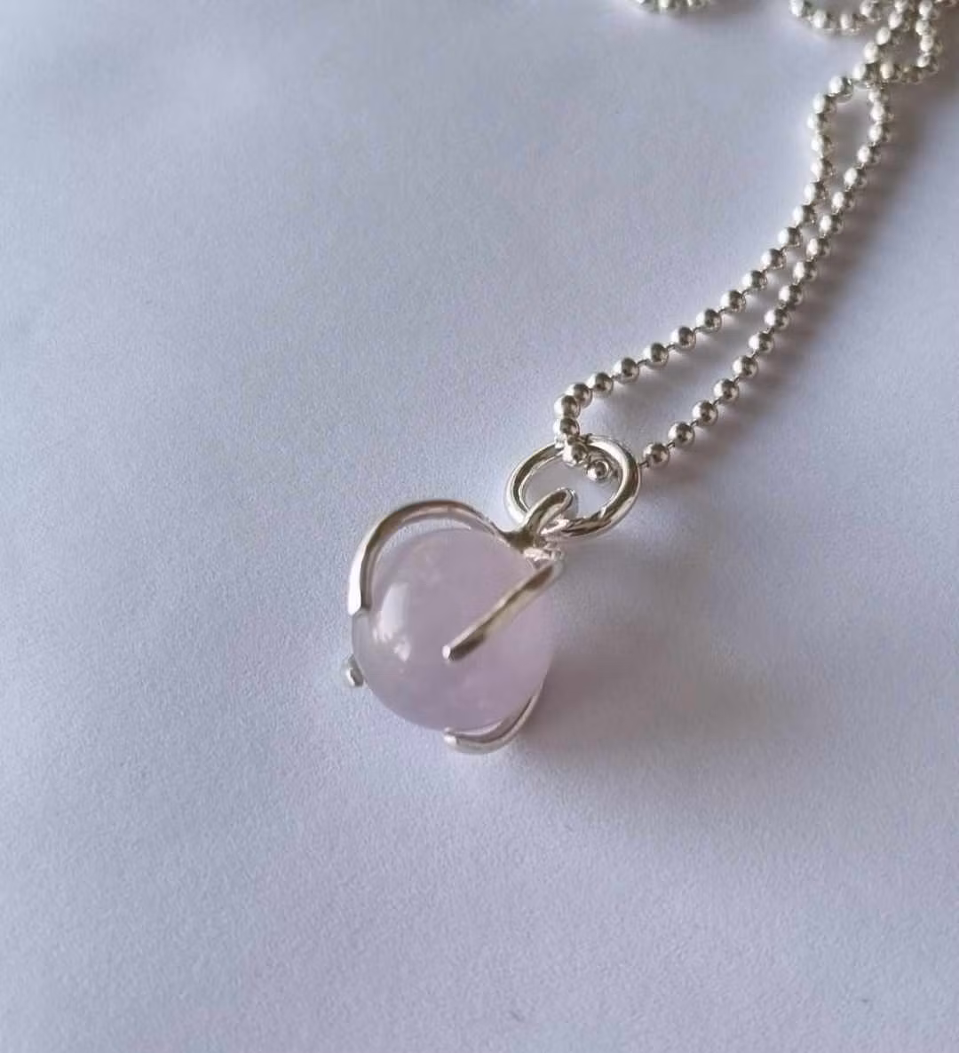 Ett fint halsband med en ljus lila/rosa sten, rund, infattad i äkta silver
