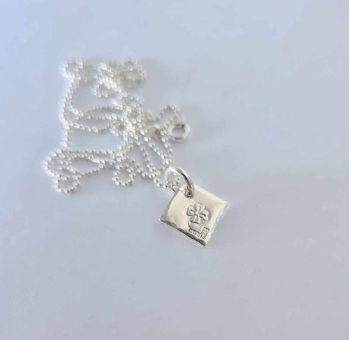 Fyrklöver ett fint halsband med en fyrklöver på silverbricka som en romb