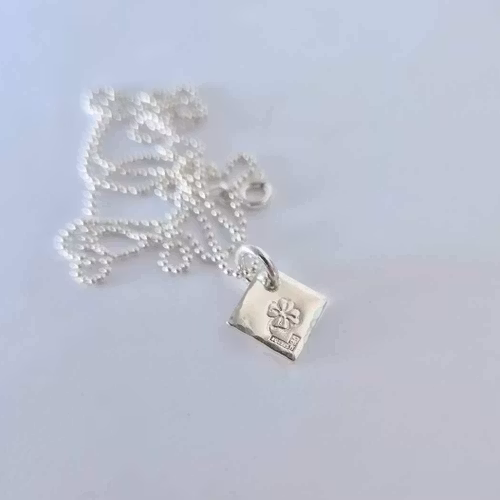 Fyrklöver ett fint halsband med en fyrklöver på silverbricka som en romb