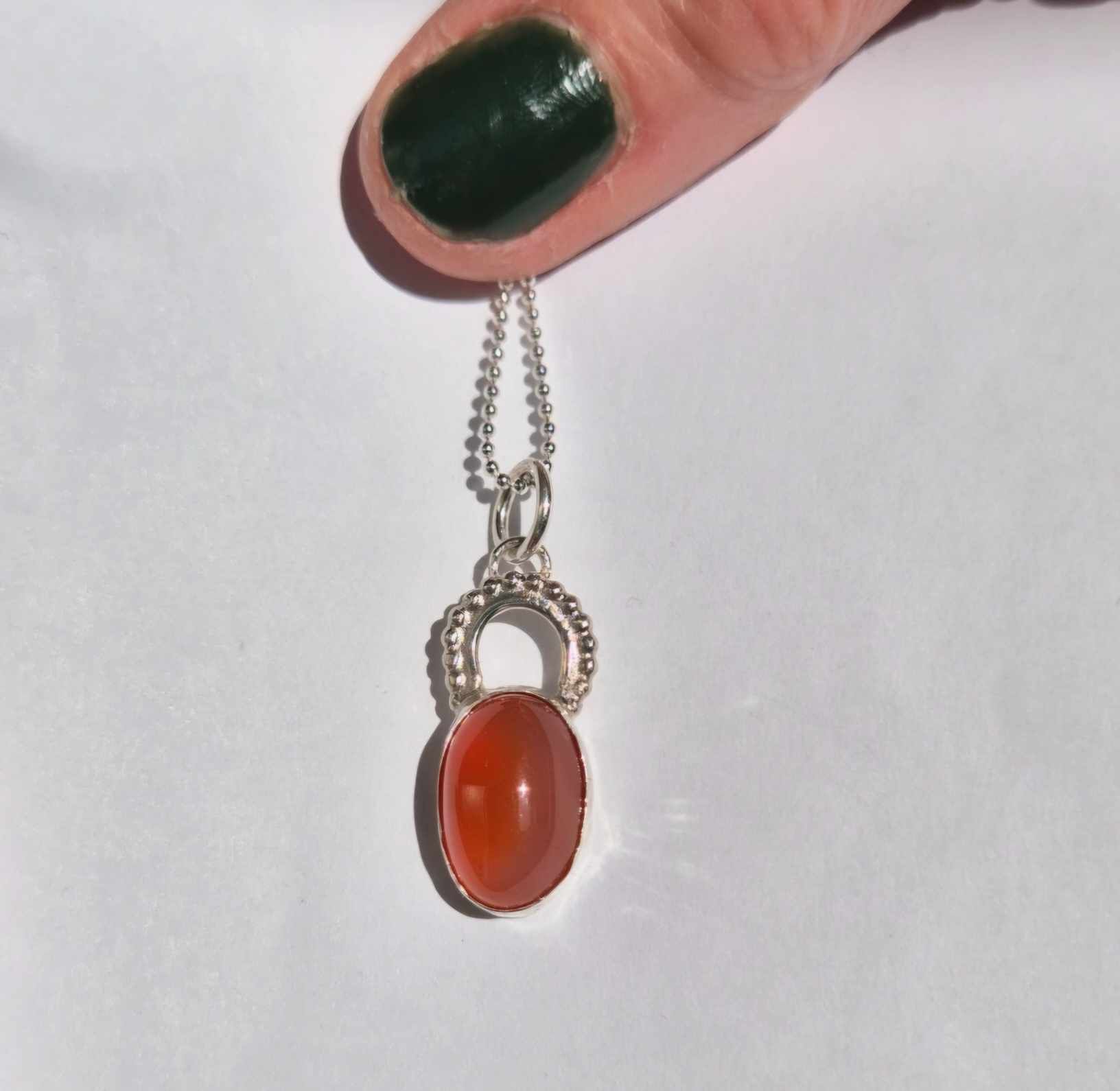 Cabochon med orange agat infattad i äkta silver