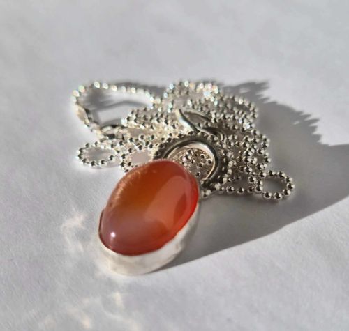 Cabochon med orange agat infattad i äkta silver