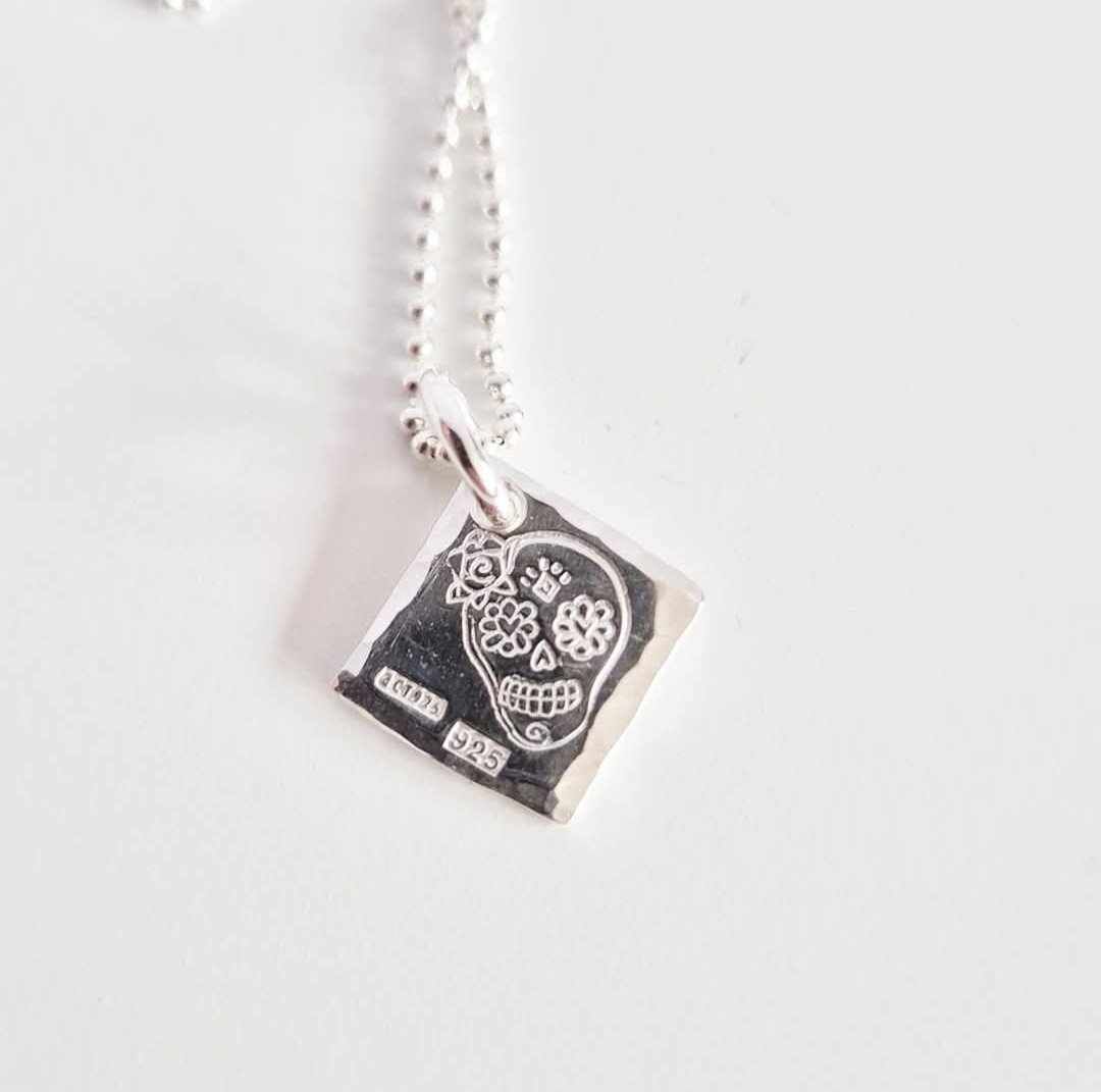 Ett fint silverhalsband med en döskalle i äkta silver HER på en silverbricka