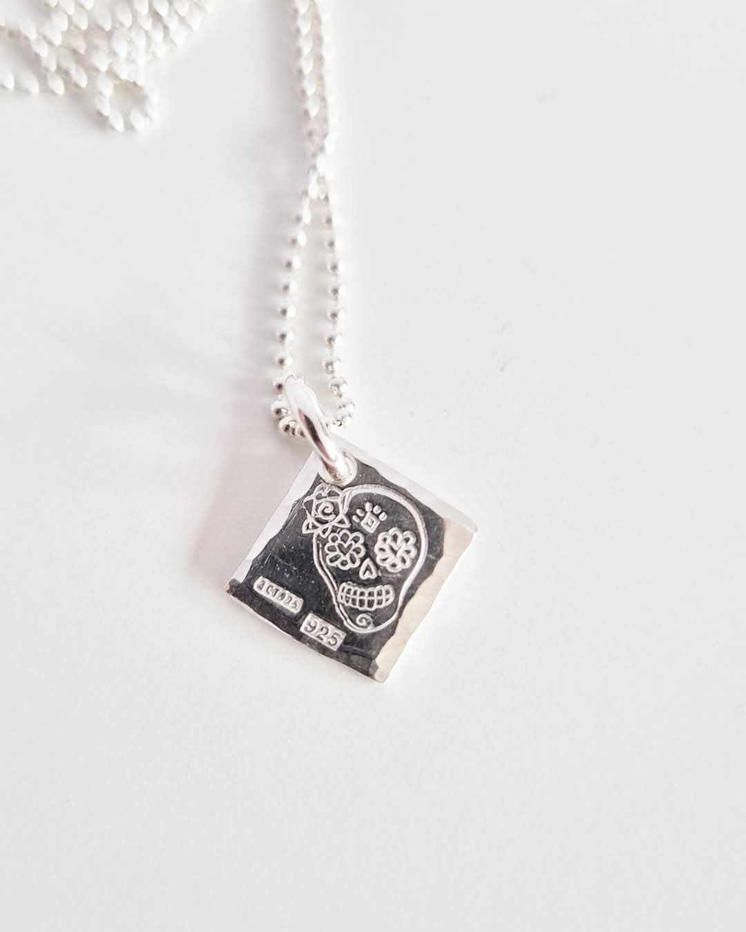 Ett fint silverhalsband med en döskalle i äkta silver HER på en silverbricka
