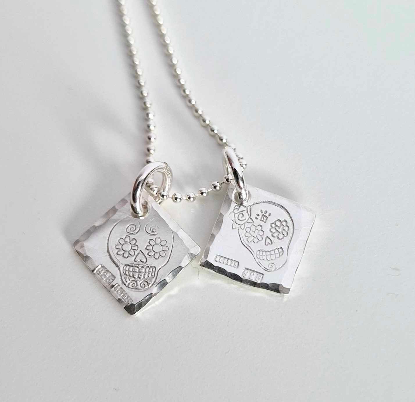 Ett fint silverhalsband med en döskalle i äkta silver HER på en silverbricka