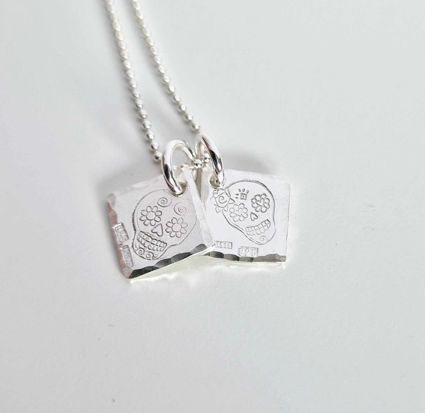 Ett fint silverhalsband med en döskalle i äkta silver HER på en silverbricka
