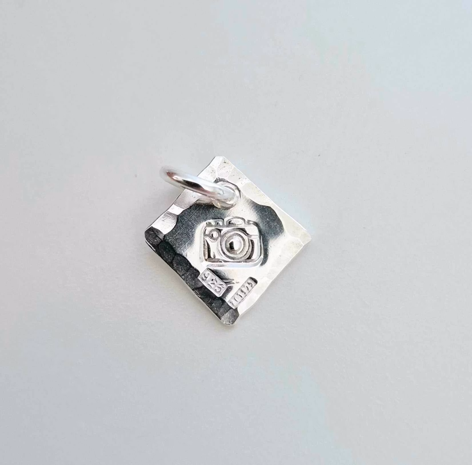 Ett fint silverhalsband med en kamera Fokus