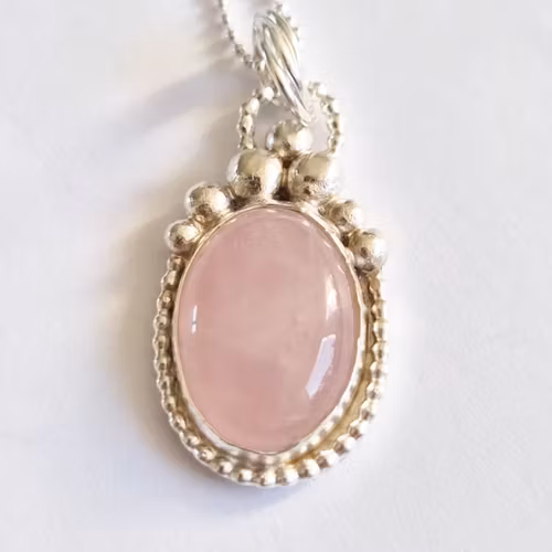 En vacker berlock med mörkare rosa rosenkvarts infattad i äkta silver