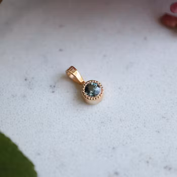 "Liljekonvalj" Hänge i rött guld med safir
