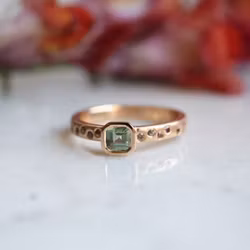 Ring med en grön och flera små rosa safirer
