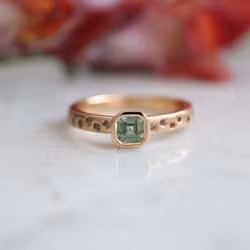 Ring med en grön och flera små rosa safirer