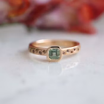 Ring med en grön och flera små rosa safirer