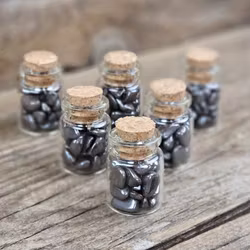 Hematit, små trumlade i glasflaska