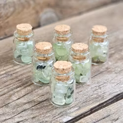 Prehnit, små trumlade i glasflaska