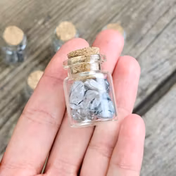 Rutilkvarts, små trumlade i glasflaska