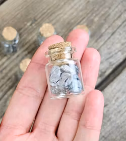 Rutilkvarts, små trumlade i glasflaska