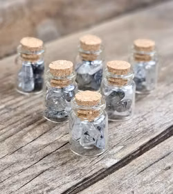 Rutilkvarts, små trumlade i glasflaska