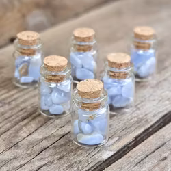 Blå Kalcedon, små trumlade i glasflaska