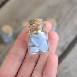 Blå Kalcedon, små trumlade i glasflaska