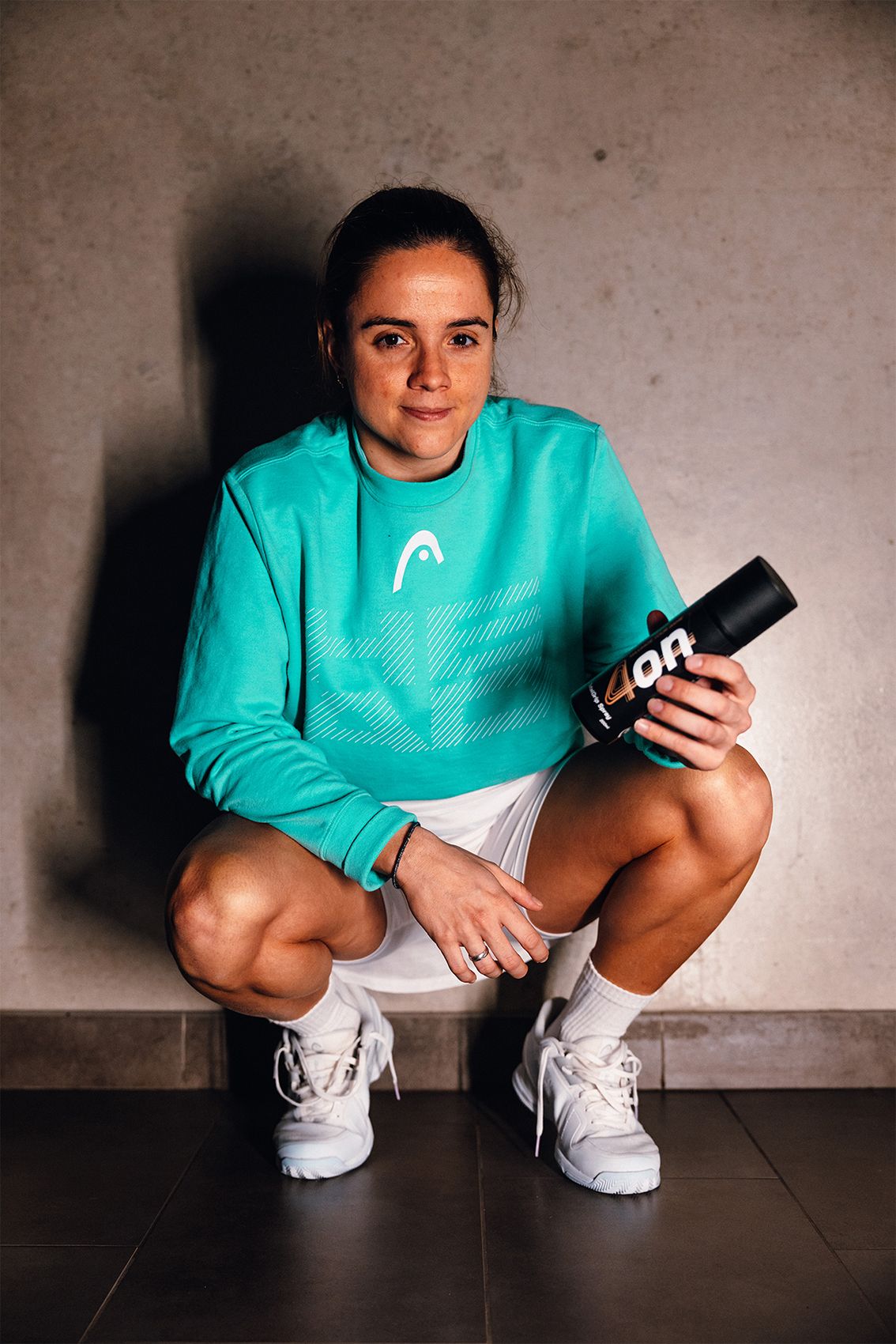 Pro padel player Paula Josemaría Martín holding a 4on TotalGrip spray.