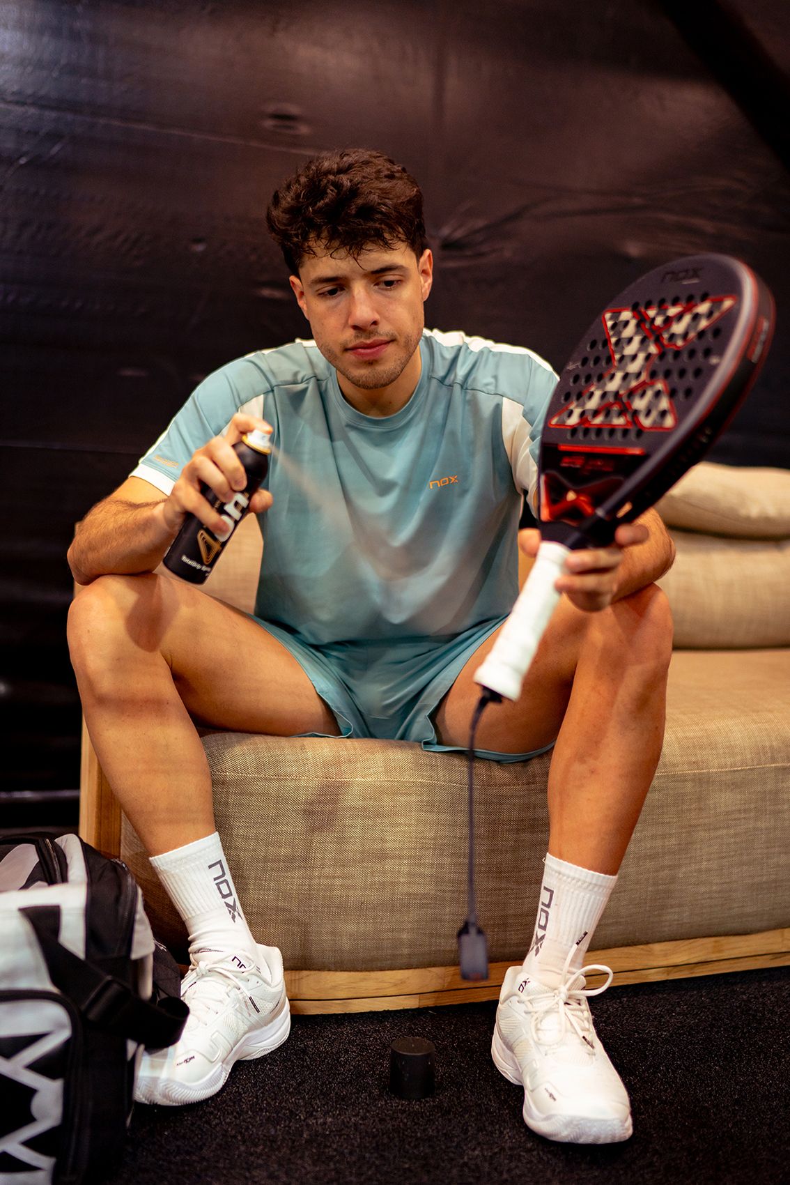 Pro padel player Agustín Tapia spraying 4on Total Grip on his racket for maximum grip.