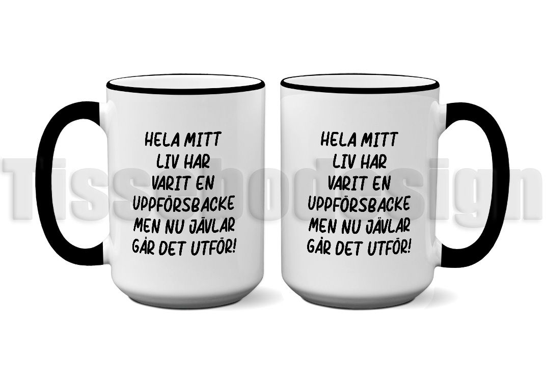 Vit keramikmugg med svart kant och handtag, med texten "Hela mitt liv har varit en uppförsbacke men nu jävlar går det utför!" tryckt på båda sidor. Rymmer 450 ml.