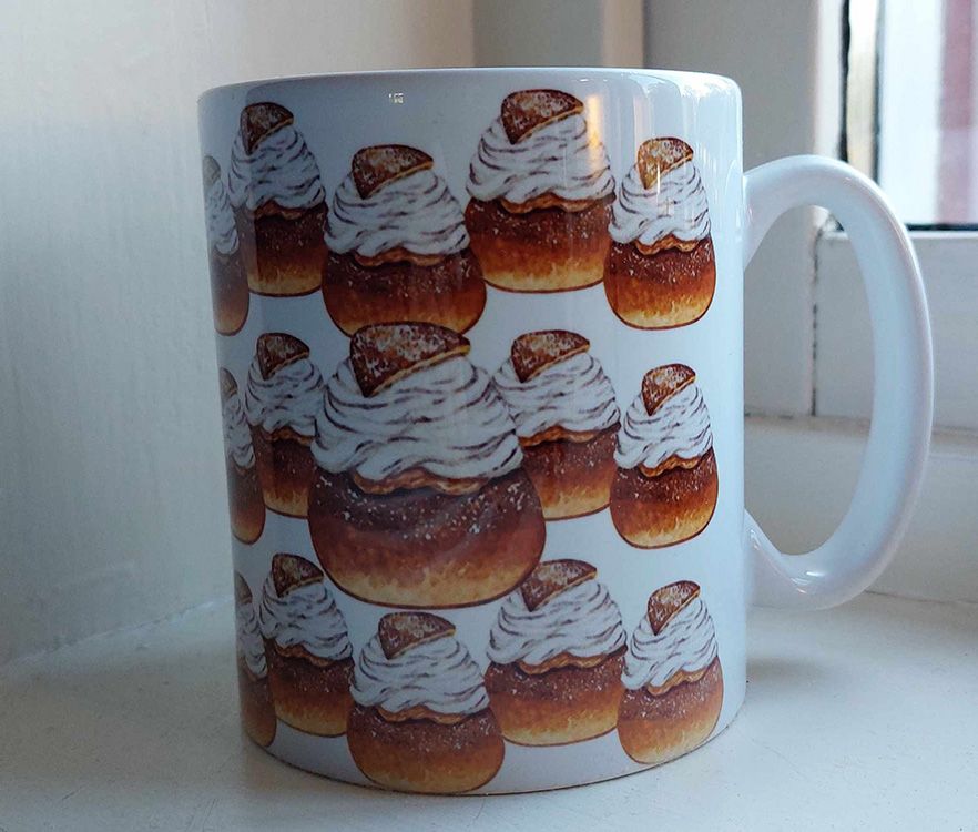 Vit keramikmugg med ett mönster av semlor runt hela muggen, 330 ml