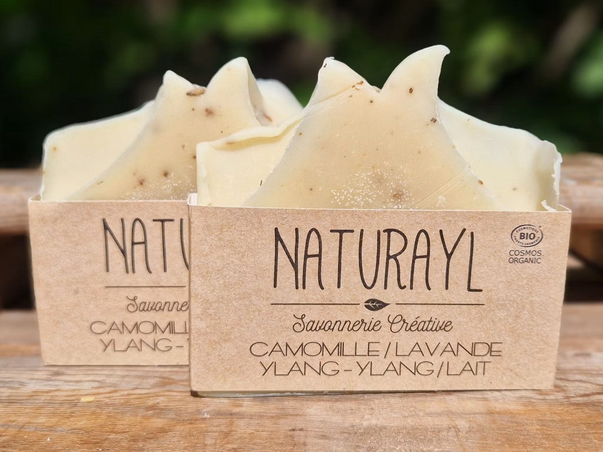 Två krämvita skurna tvålar med etikett