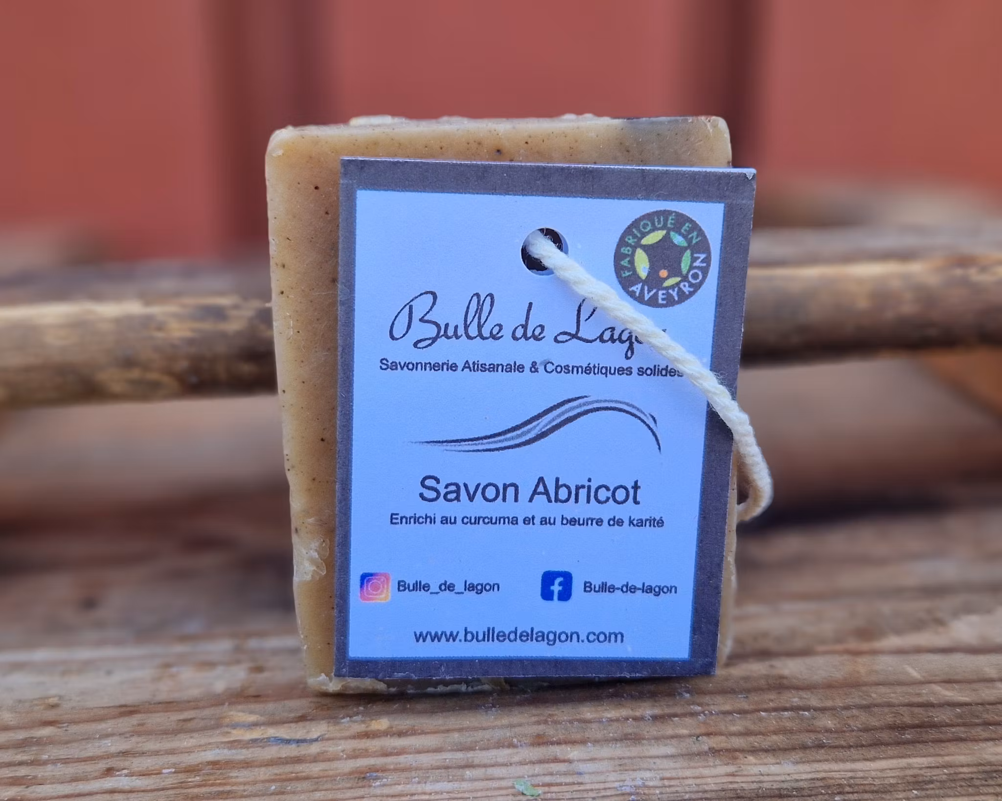 En ljust brun rektangulär tvål med etikett och snöre för upphängning