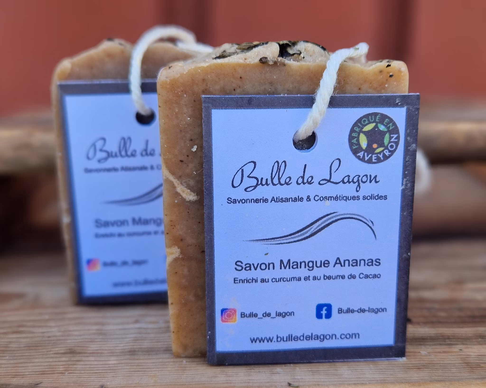 Två ljust bruna rektangulära tvålar med etikett och snöre för upphängning