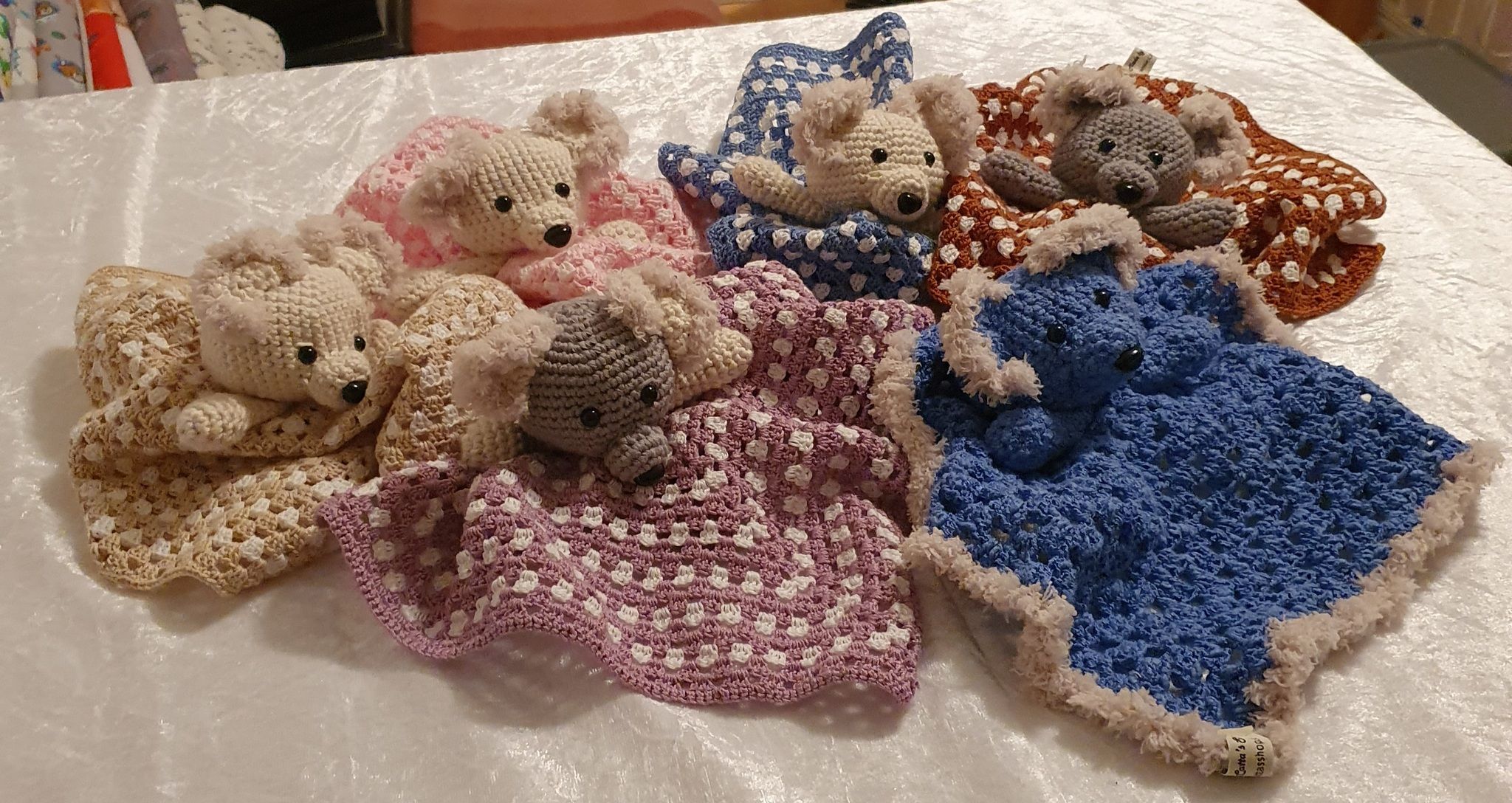 Bilden föreställer virkade snuttefiltar med nalle huvud.