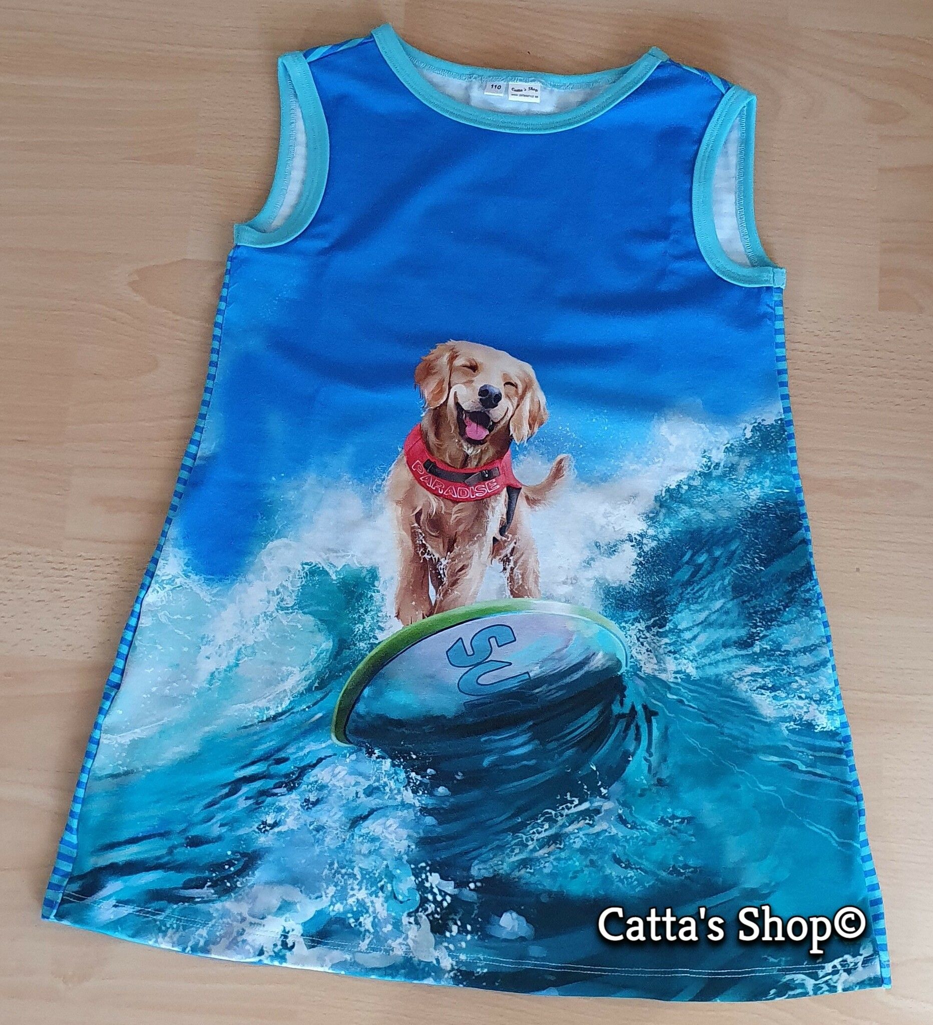 Bilden föreställer en klänning med surfande hund i ekologisk jersey/trikå.