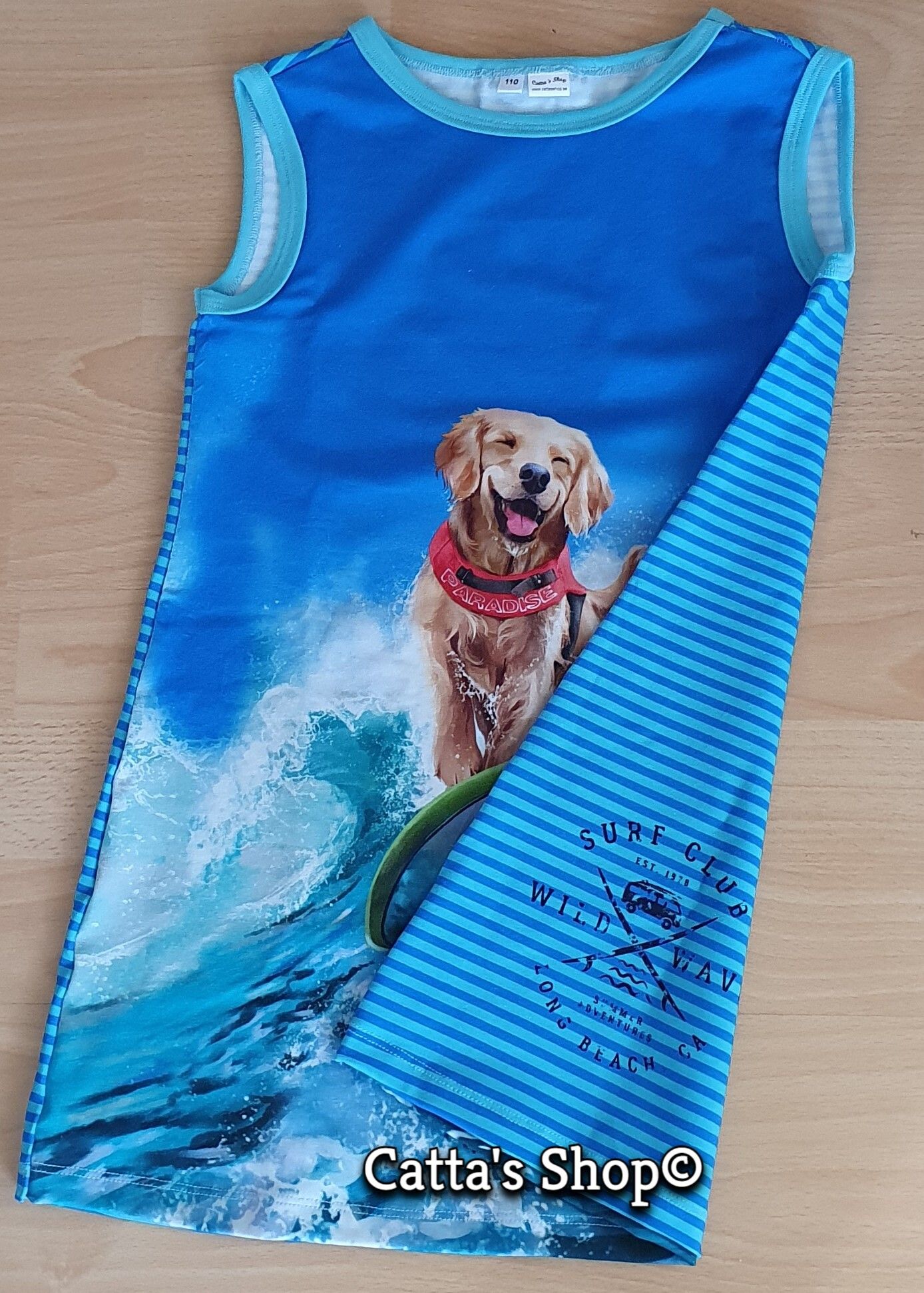 Bilden föreställer en klänning med surfande hund i ekologisk jersey/trikå.
