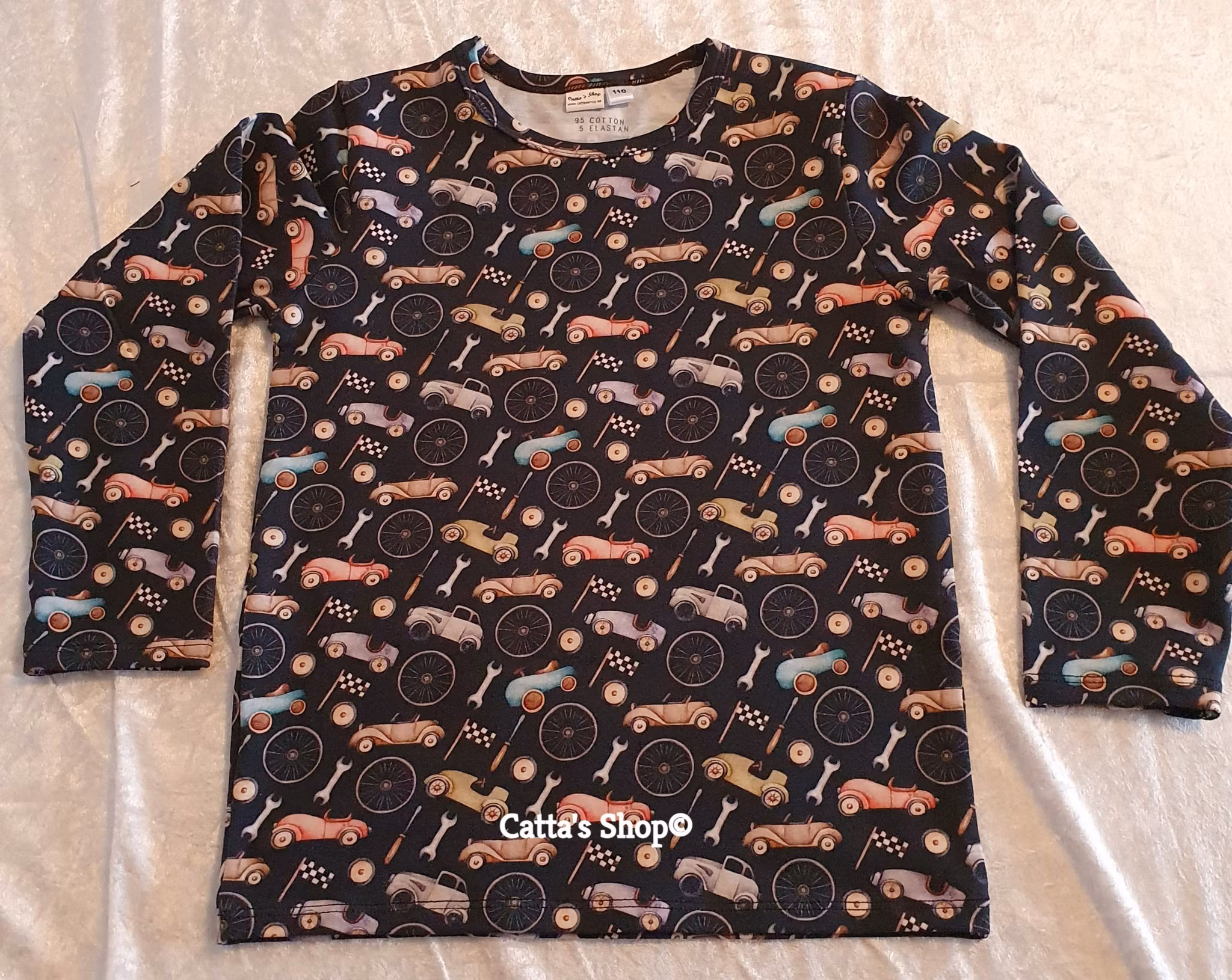 Bilden föreställer en långärmad tröja med bilar i ekologisk jersey/trikå.