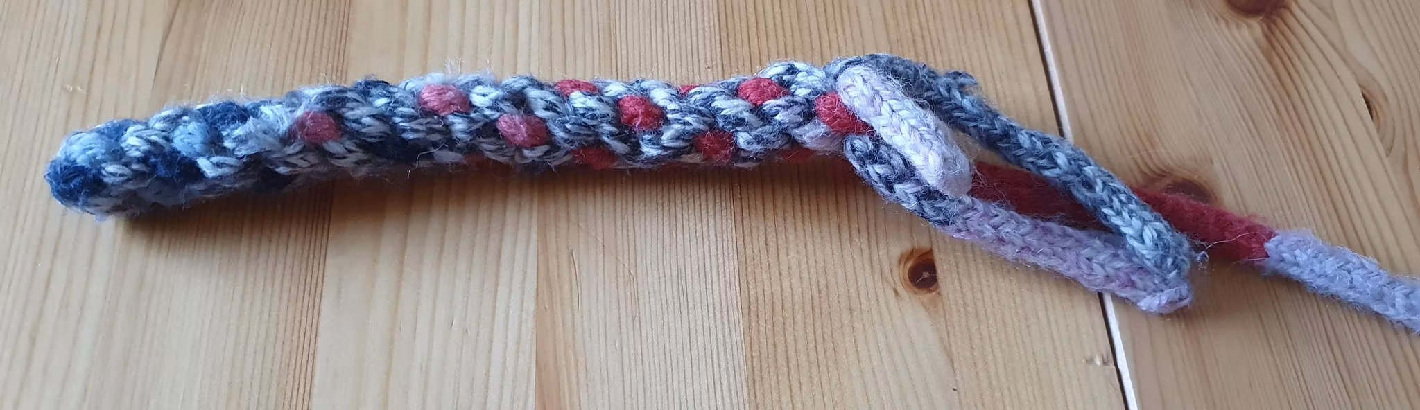 Stickad flätad hundleksak utav restgarner.