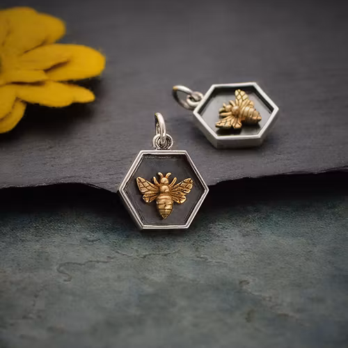 Oxiderad silverhexagon med bronsbi