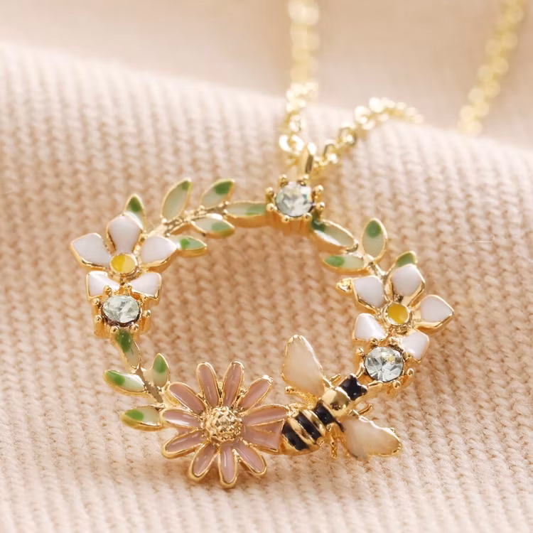 Bild på ett halsband med en blomsterkrans med ett litet bi – guld