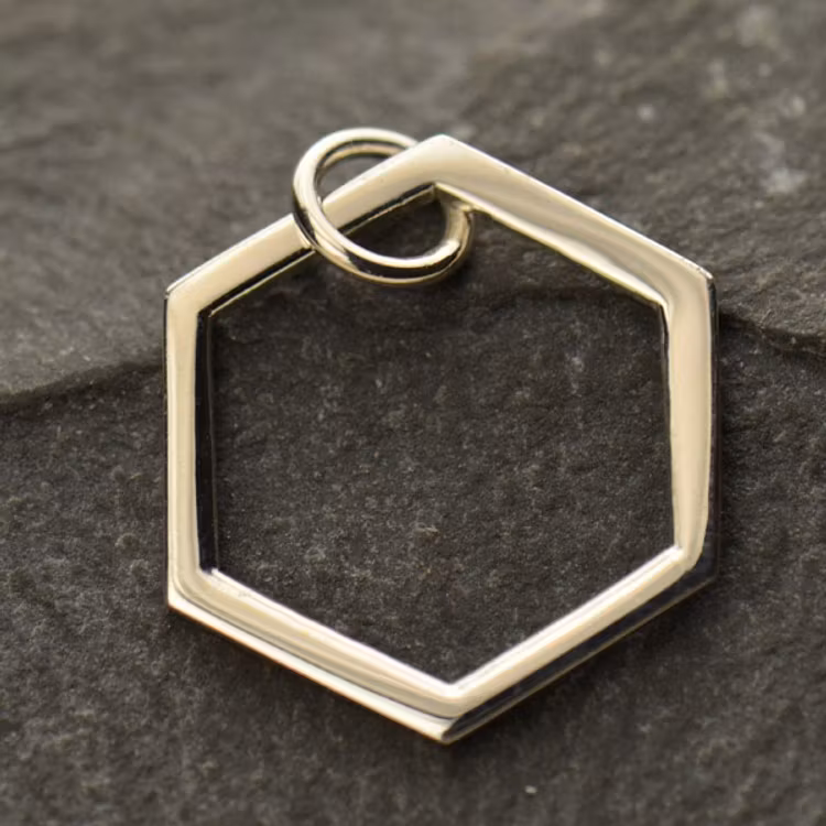 Bild på ett hänge i form av en hexagon i silver.