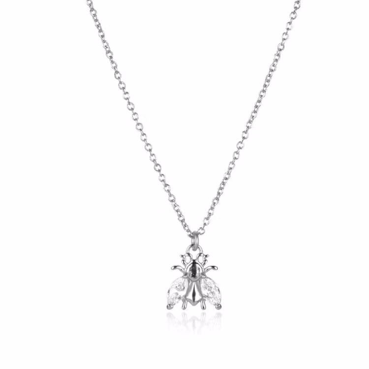 Bild på ett silverhalsband med ett bi med gnistrande vingar