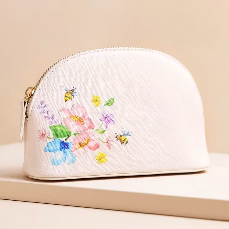 Bild på en liten necessär med blommor och bin i pastelliga färger