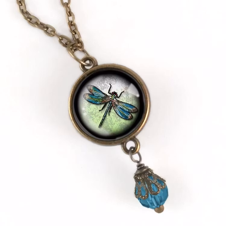 Bild på ett vintageinspirerat halsband med en berlock med en illustration av en trollslända
