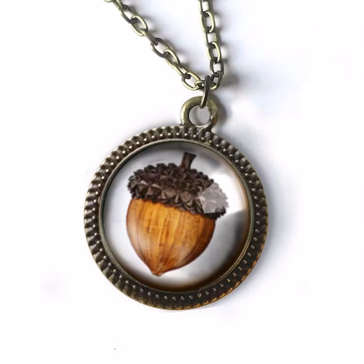 Bild på ett vintageinspirerat halsband med en illustration av ett ekollon.