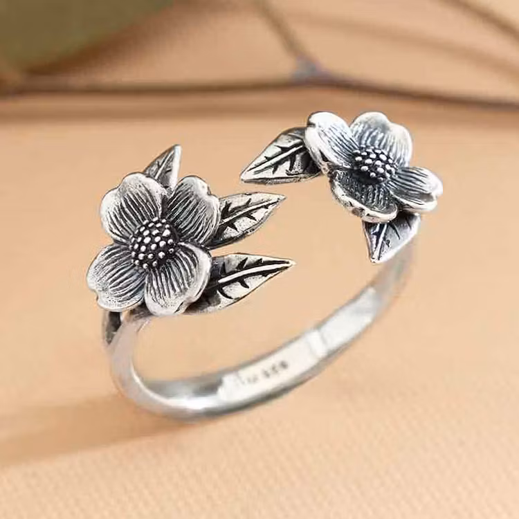 Justerbar ring i silver med två kornellblommor.
