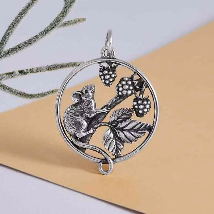 Runt silverhänge med en liten mus, björnbär och blad.