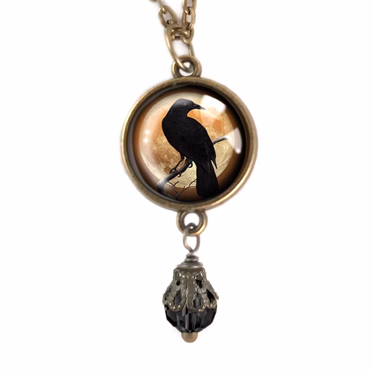Vintageinspirerat halsband med en berlock med illustration av en kråkfågel.