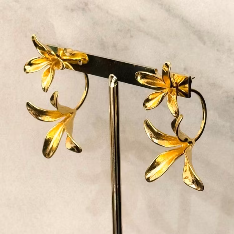Örhängen i guldpläterat rostfritt stål med två blommor där de ena "svävar" under örat.